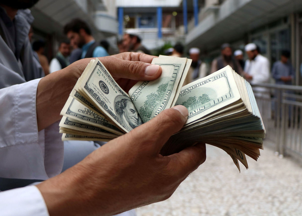 A money changer counts US dollar banknotes at money change market in Herat province, Afghanistan on 3 June 2018. Picture taken 3 June 2018. Photo: Reuters