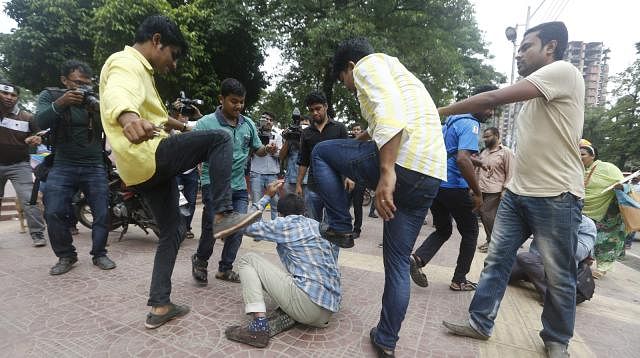 A quota reform activist is being beaten on the premises of Central Shaheed Minar. Photo: Prothom Alo