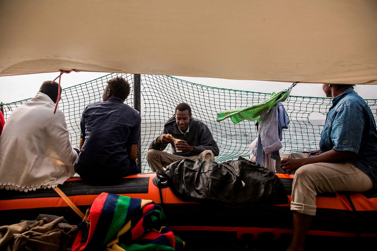 Migrants rest on the deck of the NGO Proactiva Open Arms boat on 2 July. Photo: AFP