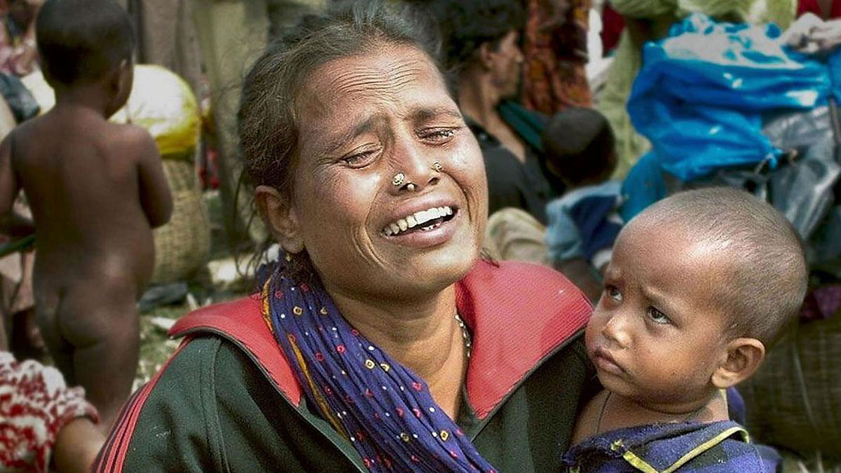 A Bangladeshi woman weeps while holding children in the no-mans-land between India and Bangladesh at the Satcachi border crossing, near Coochbehar, some 650 kms north of Kolkata. -- AFP