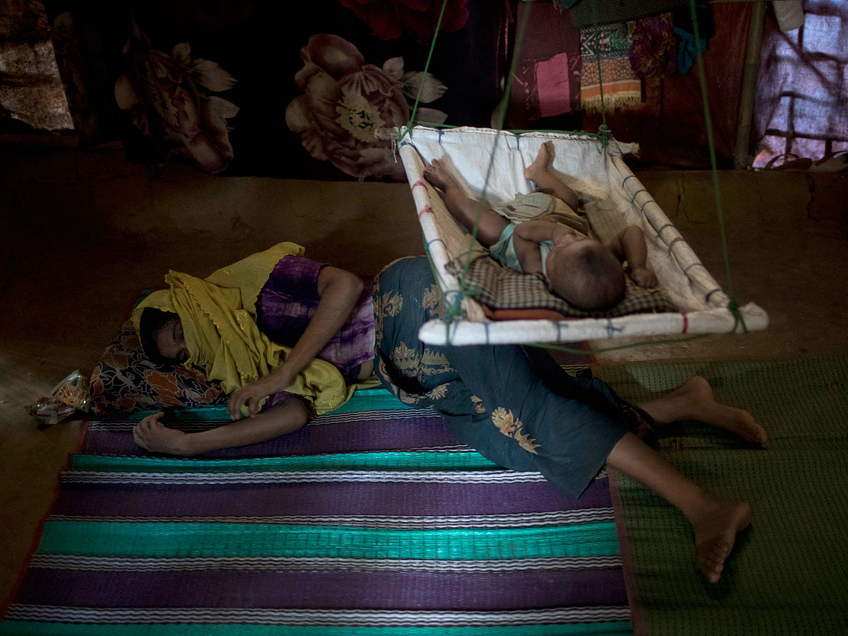 In this Tuesday, 26 June 2018, photo, ‘M lays on the floor of her shelter, uninterested in her baby boy who had awoken from his sleep, in Kutupalong refugee camp in Bangladesh. Photo: AP