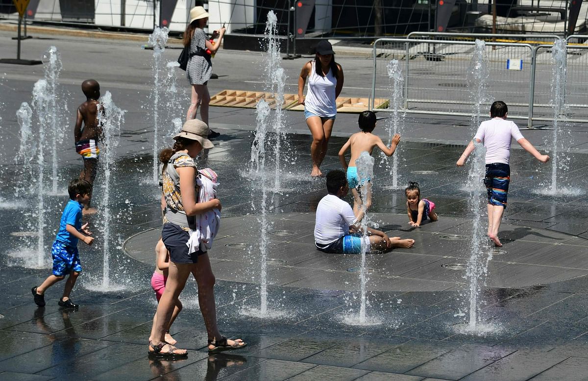 In this file photo taken on 3 July 2018, women and children play in the water fountains at the Place des Arts in Montreal, Canada on a hot summer day. A heatwave in Quebec has killed at least 17 people in the past week as high summer temperatures scorched eastern Canada, health officials said on 4 July 2018. Photo: AFP