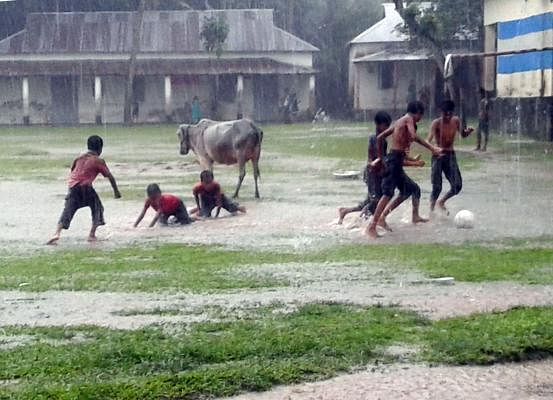 Children play in the rain at Char Kawna, Pakundia, Kishoreganj on 4 july. Photo: Tafsilul Aziz