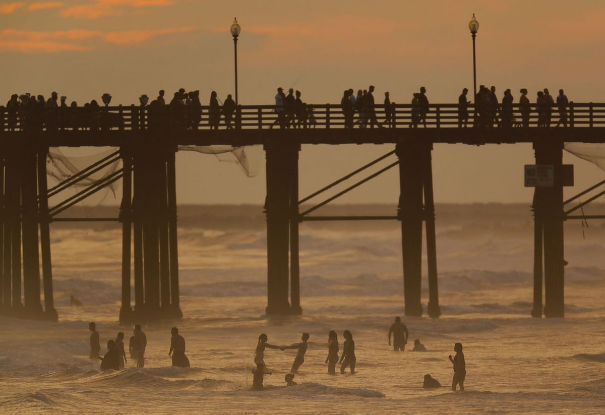 People cool off in the ocean after sunset in Oceanside, California, US on 5 July. Photo: Reuters