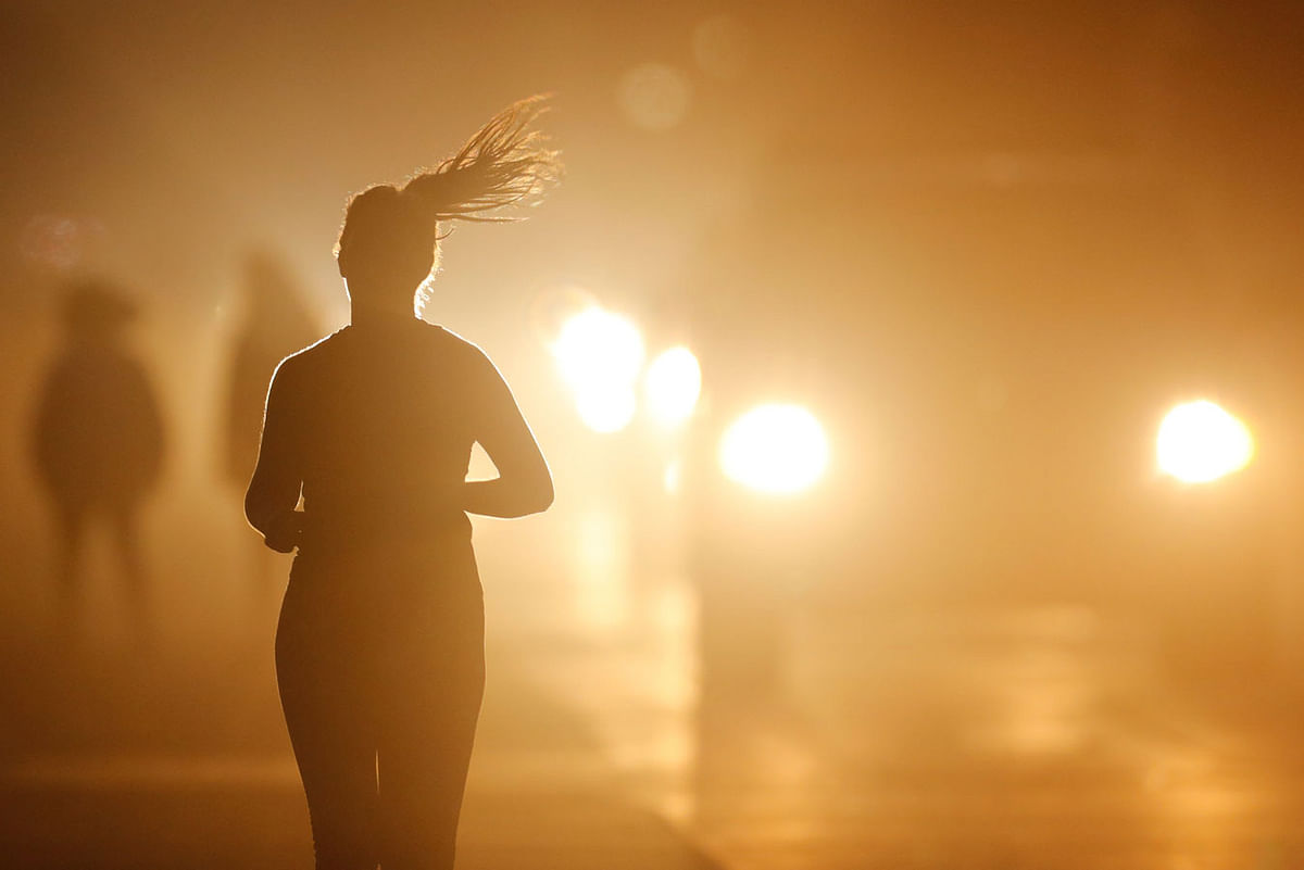 A women jogs along a roadside as temperatures cool off after sunset in Oceanside, California, US on 5 July. Photo: Reuters