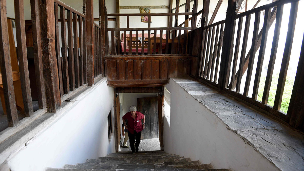 Nesip Skenduli, a toursit guide and owner of the Skenduli house walk up the stairs, in the UNESCO protected city of Gjirokastra on 14 June 2018. The Lolomani dwelling, formerly the home of the Ottoman period family of that name, was once an impressive sight in the mountainside town of Gjirokastra in southern Albania. Photo: AFP