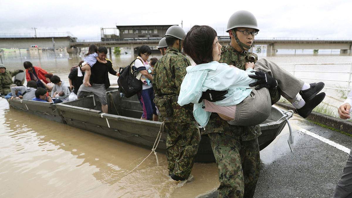 Residents are rescued from a flooded area by Japan Self-Defense Force soldiers in Kurashiki, southern Japan, in this photo taken by Kyodo on 7 July 2018. Photo: Reuters