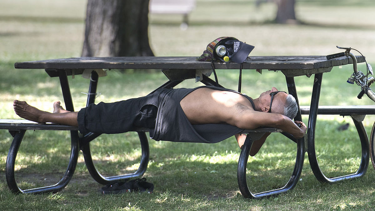 A man relaxes under a tree in a park in Montreal, Thursday, on 5 July 2018. Heat warnings are in effect across southern Quebec, Ontario and the Atlantic region of the country, but temperatures are expected to drop overnight. Photo: AP