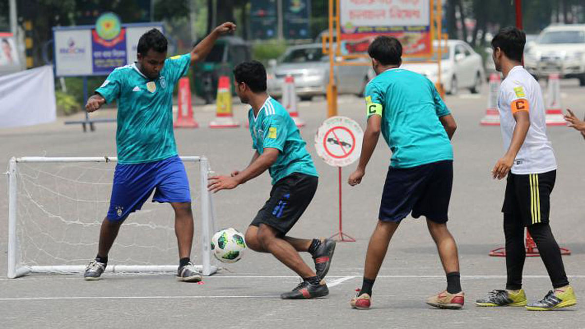 Amateur players are seen to participating in a game of `World Car-free Football Tournament` organised at Manik Mia Avenue, Dhaka on 6 July 2018. The participators put on jerseys of different countries` that are playing in the FIFA World Cup 2018. The event was held demanding a car-free city. Photo: Zahidul Karim