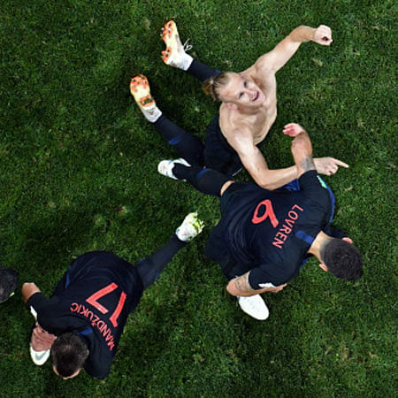 Croatia`s defender Domagoj Vida (up) is congratulated by teammates after scoring a goal during the Russia 2018 World Cup quarter-final football match between Russia and Croatia at the Fisht Stadium in Sochi on 7 July 2018. -- AFP