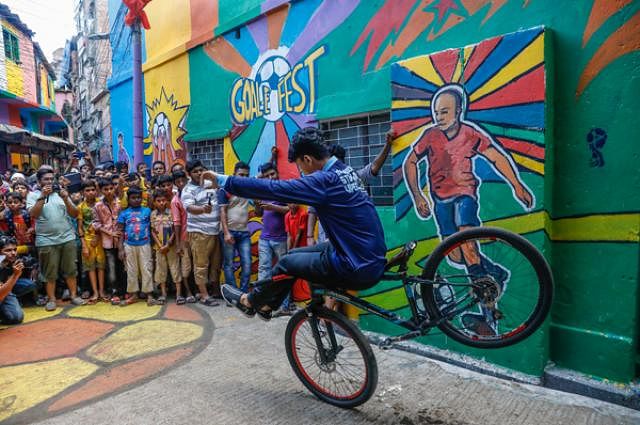 People watch a stunt performing with a bicycle.