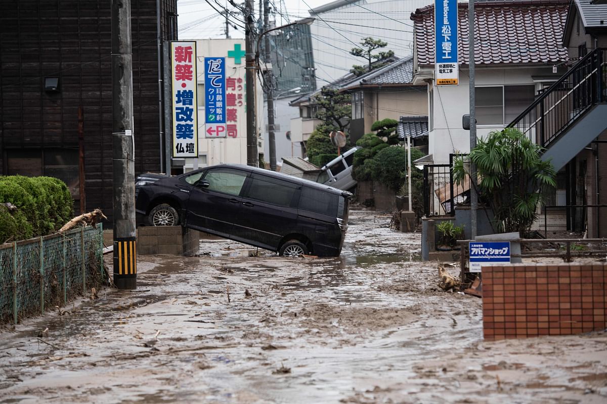 A picture shows cars trapped in the mud after floods in Saka, Hiroshima prefecture on July 8, 2018. Japan`s Prime Minister Shinzo Abe warned on July 8 of a `race against time` to rescue flood victims as authorities issued new alerts over record rains that have killed at least 48 people. AFP
