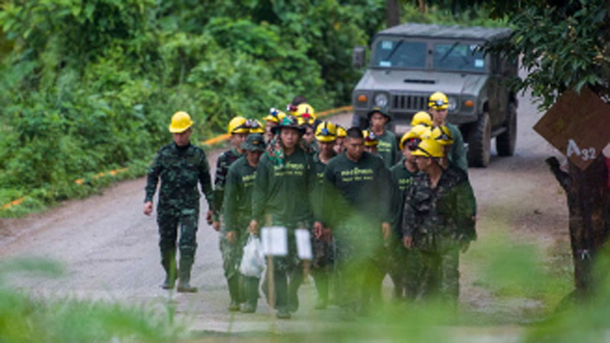 Thai soldiers walk out from the Tham Luang cave area as operations continue for the 8 boys and their coach trapped at the cave in Khun Nam Nang Non Forest Park in the Mae Sai district of Chiang Rai province on 9 July 9. Four boys among the group of 13 trapped in a flooded Thai cave for more than a fortnight were rescued on 8 July after surviving a treacherous escape, raising hopes elite divers would also save the others soon.  -- AFP