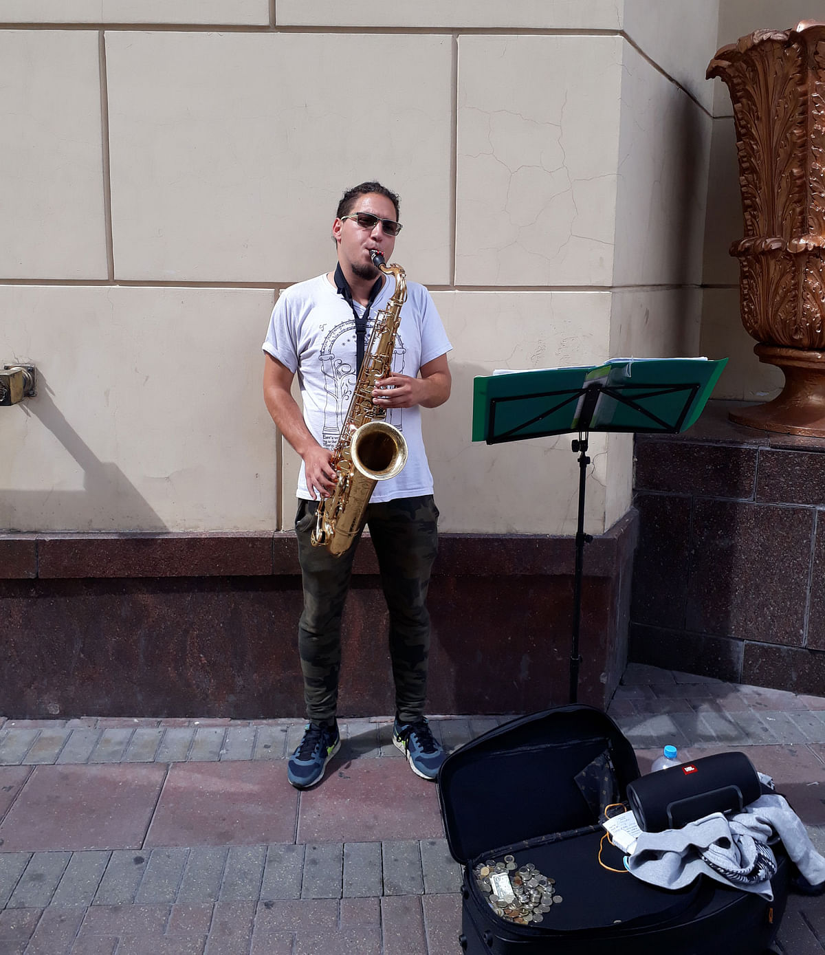 A musician plays a saxophone next to a tourist joint. He later collected money donated by the passersby.Photo: Quamrul Hassan