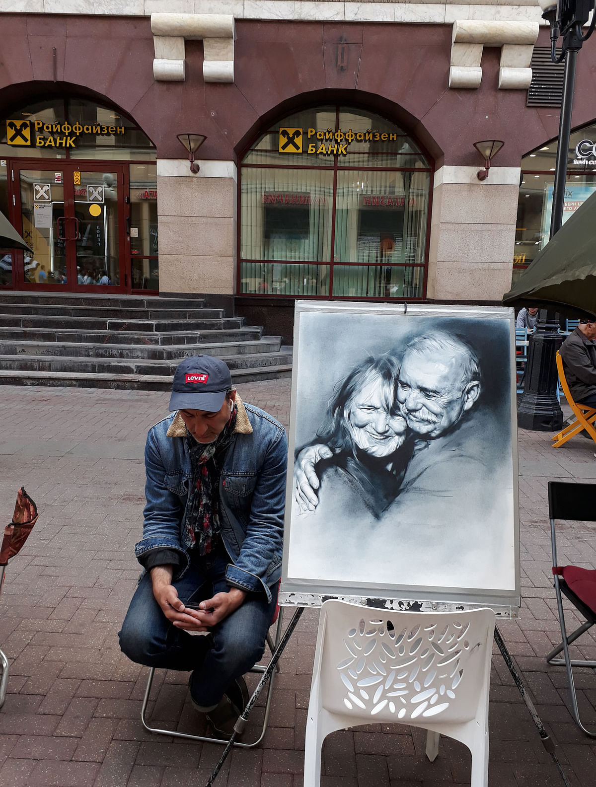 A street artist doses off next to his artwork.Photo: Quamrul Hassan