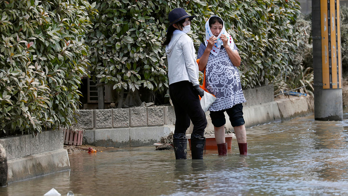 Local residents stand in a flooded area in Mabi town in Kurashiki, Okayama Prefecture, Japan on 10 July 2018. Photo: Reuters