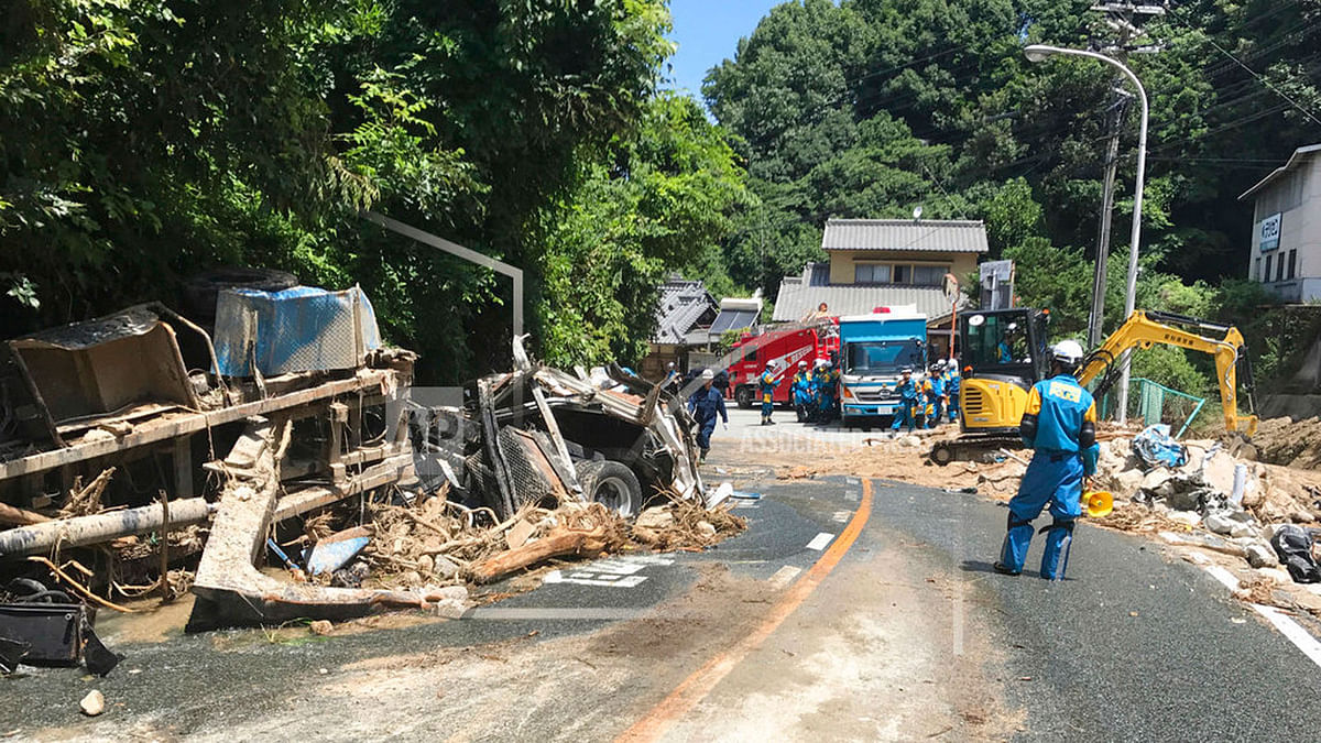 Rescuers clear the debris of damaged houses and vehicles after a mudslide hit Hiroshima, southwestern Japan, Tuesday, 10 July  2018. Rescuers were combing through mud-covered hillsides and along riverbanks Tuesday searching for dozens of people missing after heavy rains unleashed flooding and mudslides in southwestern Japan.