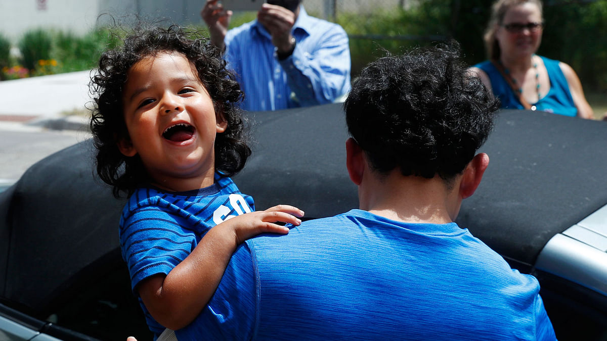 Ever Reyes Mejia, of Honduras, carries his son to a vehicle after being reunited and released by United States Immigration and Customs Enforcement in Grand Rapids, Mich, on 10 July. Photo: AP