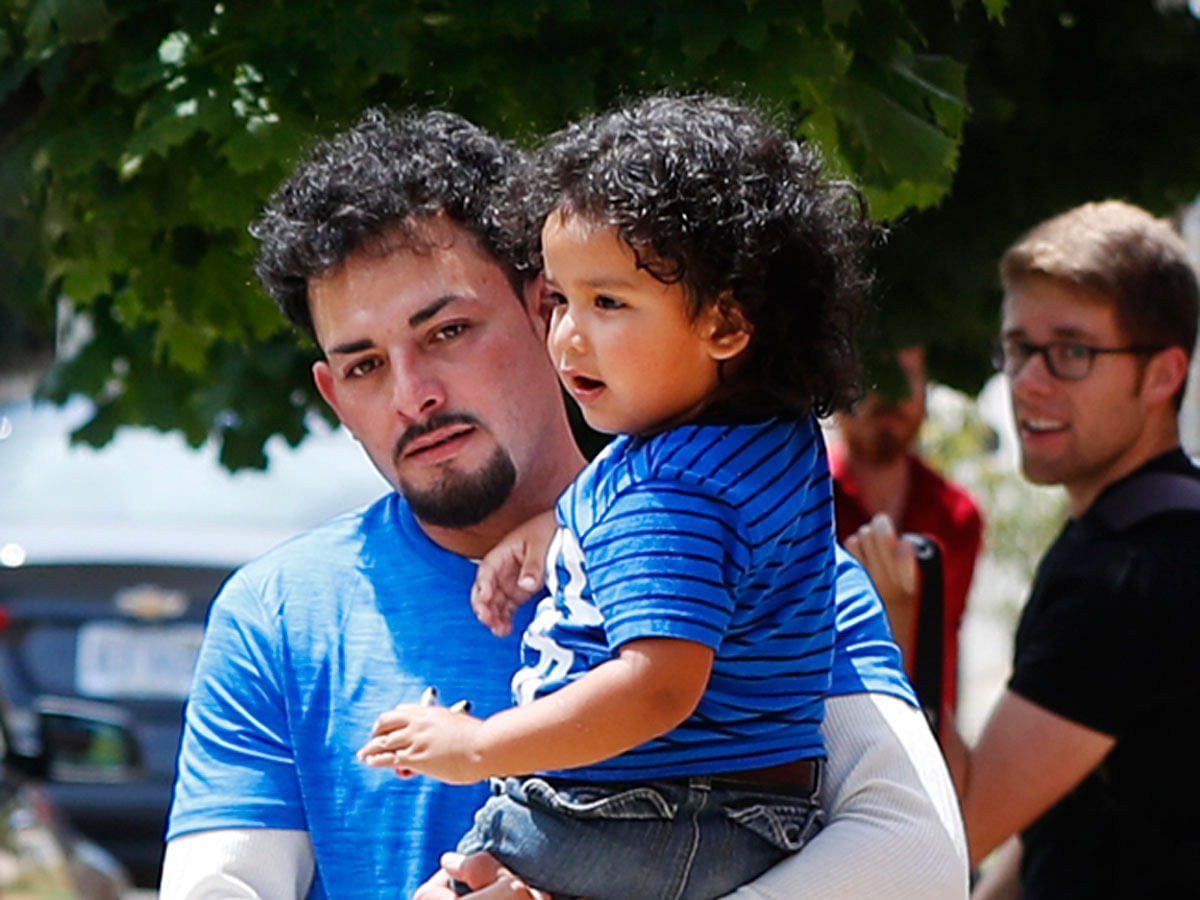 Ever Reyes Mejia, of Honduras, carries his son to a vehicle after being reunited and released by United States Immigration and Customs Enforcement in Grand Rapids, Mich., Tuesday, 10 July 2018. Two boys and a girl who had been in temporary foster care in Grand Rapids, were reunited with their Honduran fathers after they were separated at the US-Mexico border about three months ago. Photo : AP