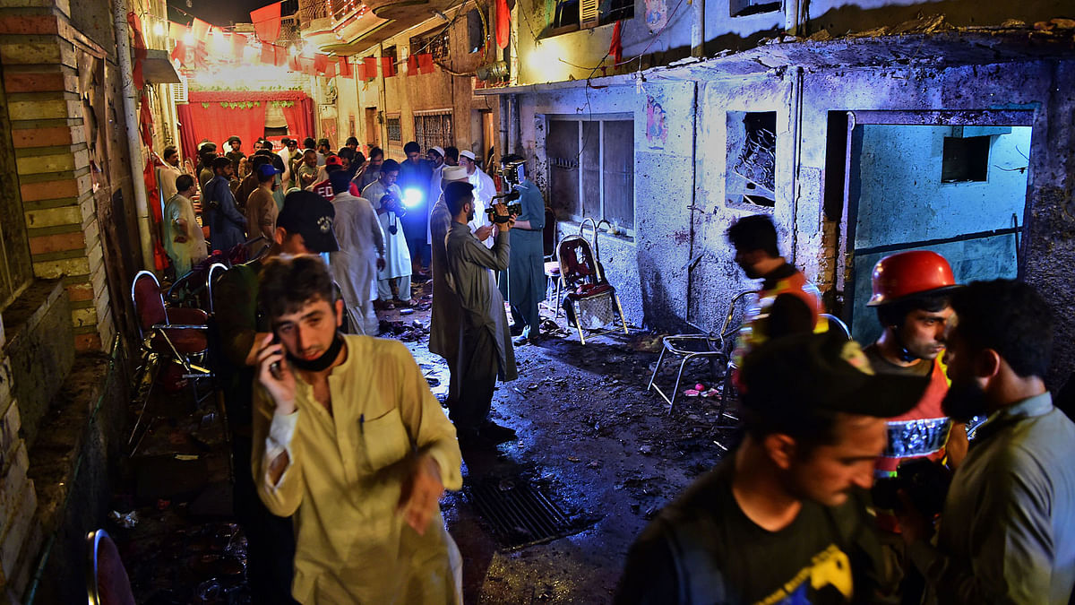 Pakistani security officials and volunteers search the site after a suicide bombing at an election rally in Peshawar on 10 July. Photo: AFP