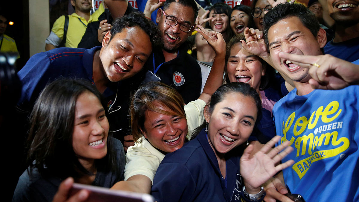 Journalists celebrate after a news conference near Tham Luang cave complex in the northern province of Chiang Rai, Thailand on 10 July 2018. Photo: Reuters