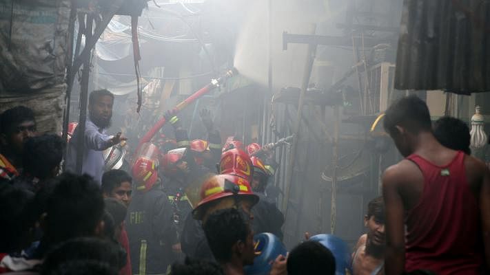 Fire breaks out from a shop in the Hasina Market in Karwan Bazar of Dhaka on Wednesday afternoon. In this photo taken on 11 July by Zahidul Karim, fire service workers are seen trying to extinguish the fire.