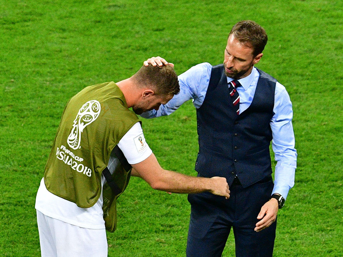 England midfielder Jordan Henderson (L) is being consoled by coach Gareth Southgate after their semifinal loss to Croatia at the Luzhniki Stadium in Moscow on July 11, 2018. AFp