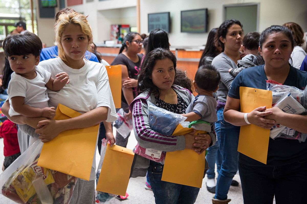 In this file photo taken on 17 June 2018 immigrants wait to head to a nearby Catholic Charities relief centre after being dropped off at a bus station shortly after release from detention through “catch and release” immigration policy in McAllen, Texas. Photo: AFP