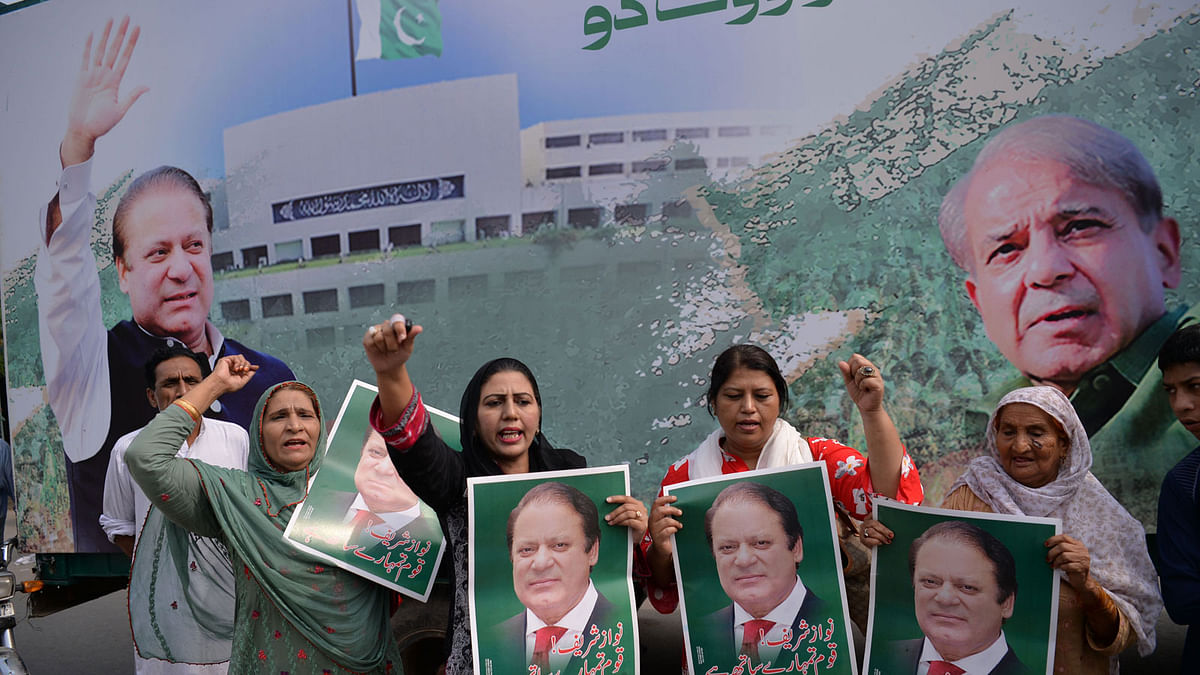 Supporters of Pakistan`s ousted prime minister Nawaz Sharif hold posters of him and chant slogans as they gather at the venue where his younger brother Shahbaz Srarif will lead a rally towards the airport ahead of the arrival of Nawaz from London, in Lahore on 13 July 2018. Photo: AFP