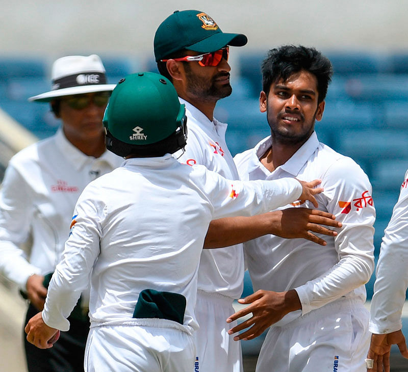 amim Iqbal (L) and Mehidy Hasan Miraz (R) of Bangladesh celebrate the dismissal of Kieran Powell of West Indies during day 1 of the 2nd Test between West Indies and Bangladesh at Sabina Park, Kingston, Jamaica, on 12 July, 2018. Photo: AFP