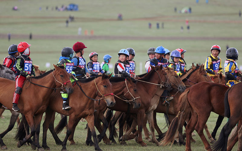 Child jockeys riding horses head to the start line for the Soyolon horse race at the Mongolian traditional Naadam festival, on the outskirts of Ulaanbaatar, Mongolia on 12 July 2018. Photo: Reuters
