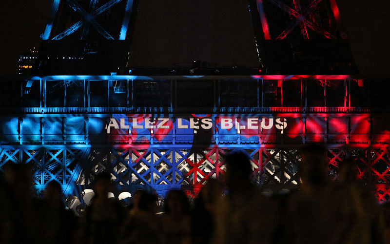 The Eiffel Tower is illuminated in France`s colours and reading `Go [French football national team] les bleus` during the annual Bastille Day celebration in Paris, on 14 July 2018, the eve of the Russia 2018 World Cup final football match between France and Croatia. Photo: AFP