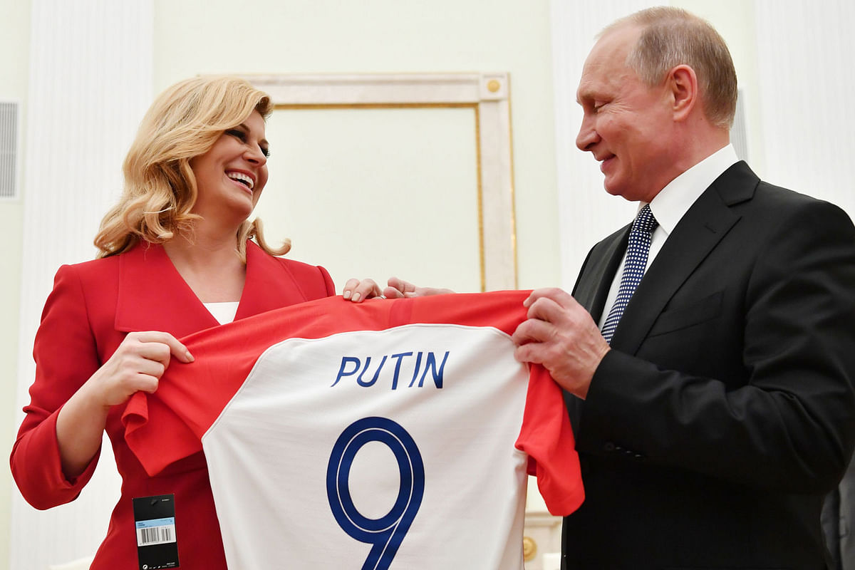 Croatian president Kolinda Grabar-Kitarovic (L) offers to Russian president Vladimir Putin a jersey of the Croatian national football team bearing the name Putin, ahead of the Russia 2018 World Cup final football match between France and Croatia, during their meeting at the Kremlin in Moscow on 15 July 2018. Photo: AFP