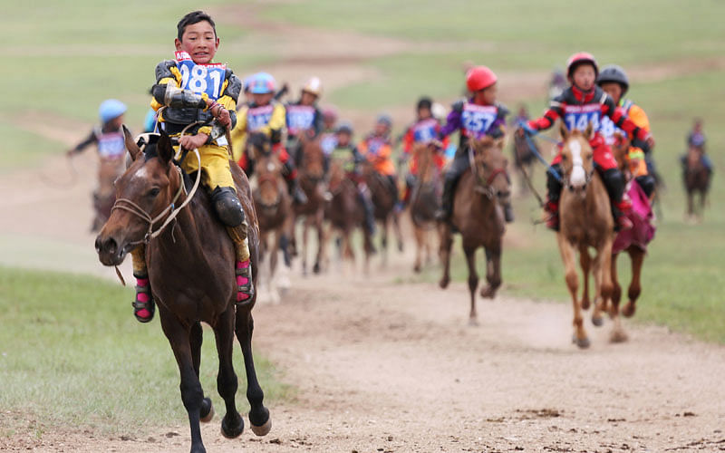 Child jockeys ride their horses to the finish line during a horse race at the Mongolian traditional Naadam festival, on the outskirts of Ulaanbaatar, Mongolia on 12 July 2018. Photo: Reuters
