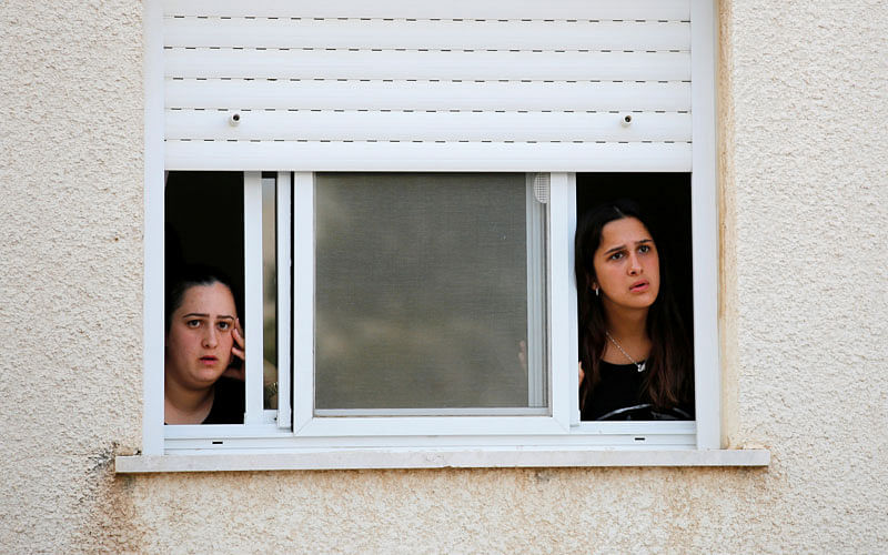 Israeli teens look out of a window at the southern city of Sderot, on the Israeli side of the Israel - Gaza border on 14 July 2018. Photo: Reuters