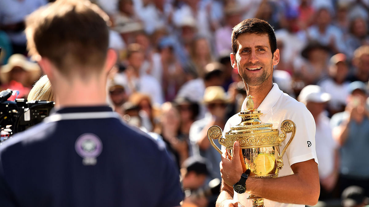Serbia`s Novak Djokovic smiles as he holds the winners trophy after beating South Africa`s Kevin Anderson in their men`s singles final match on the thirteenth day of the 2018 Wimbledon Championships at The All England Lawn Tennis Club in Wimbledon, southwest London, on 15 July. Photo: AFP