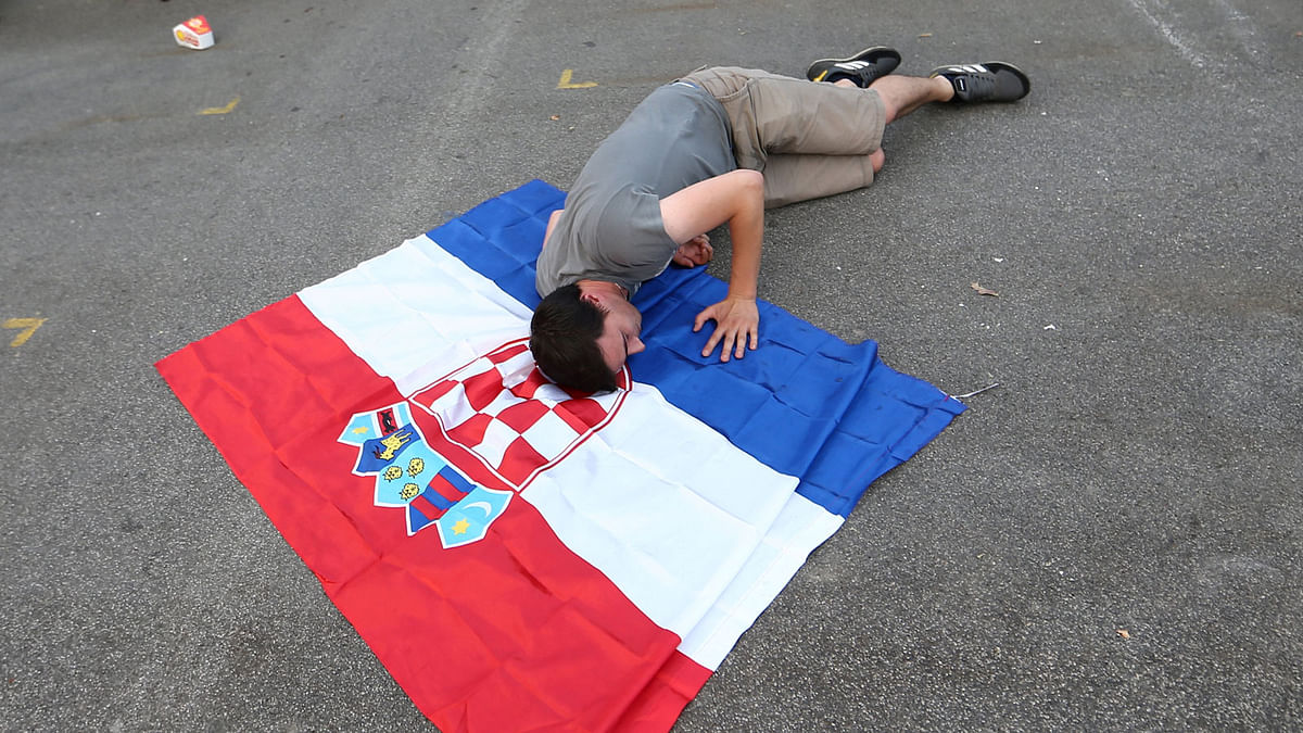 Croatia`s fans lies on the Croatian flag after the broadcast of the match at the city`s main square. Photo: Reuters