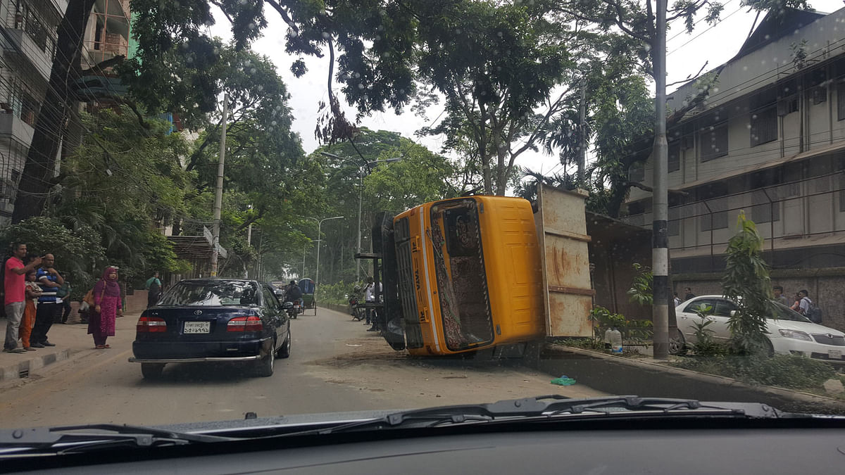 A stone-laden truck from Sylhet overturns on an island as the driver loses his control near Asad Avenue in capital`s Mohammadpur on 16 July. Photo: Sadman Saqib Al Mohsi