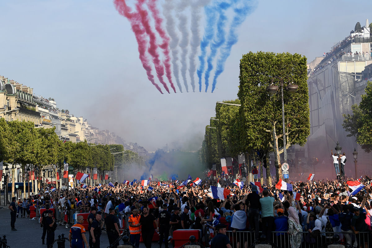 The Patrouille de France jets perform as they trail smoke in the colours of the French national flag while flying over the Champs Elysee avenue as supporters welcome players of the French national football team after they won the Russia 2018 World Cup final football match, in Paris, France 16 July, 2018. Photo: Reuters