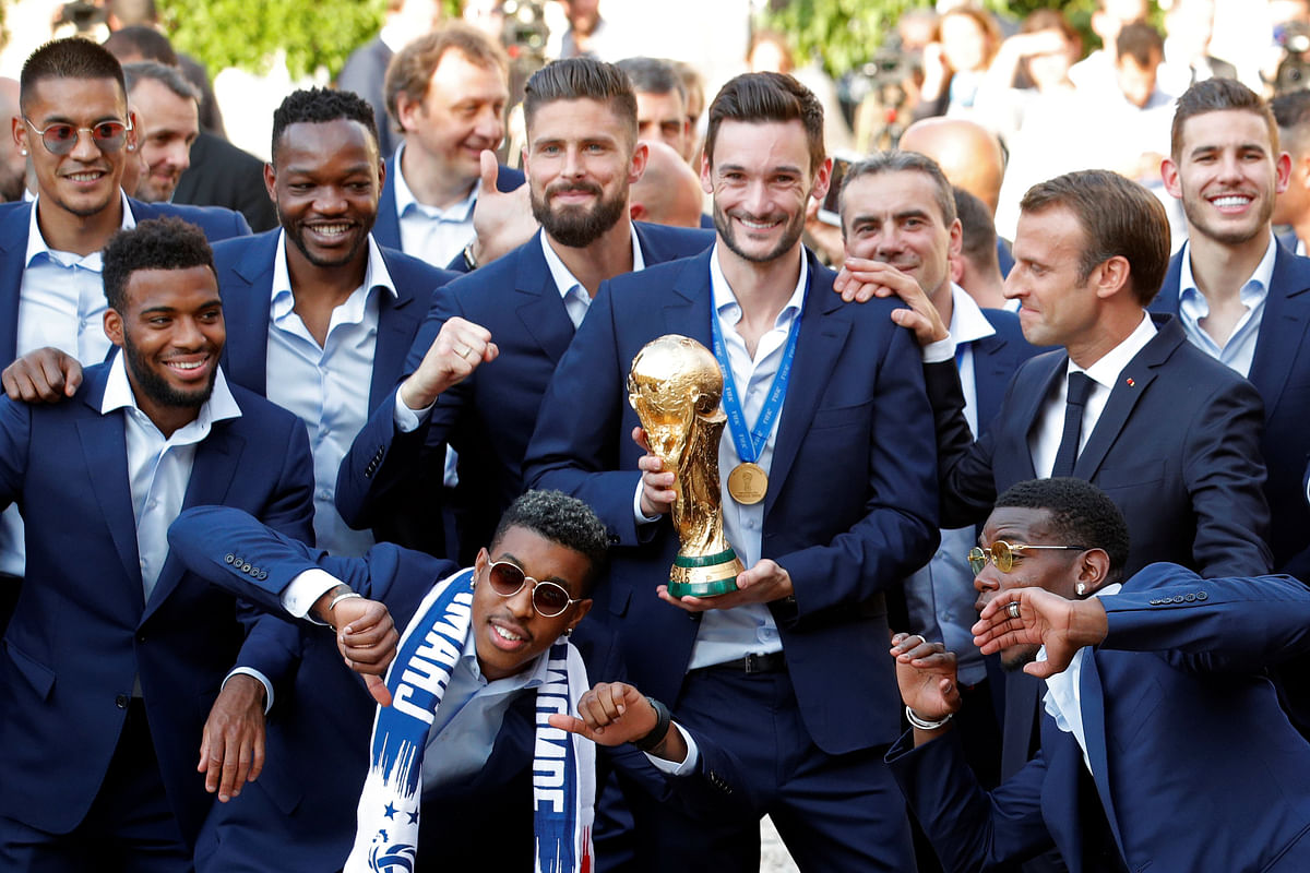 French president Emmanuel Macron reacts with France soccer team captain Hugo Lloris holding the trophy, and players before a reception to honour the France soccer team after their victory in the 2018 Russia Soccer World Cup, at the Elysee Palace in Paris, France, 16 July, 2018. Photo: Reuters