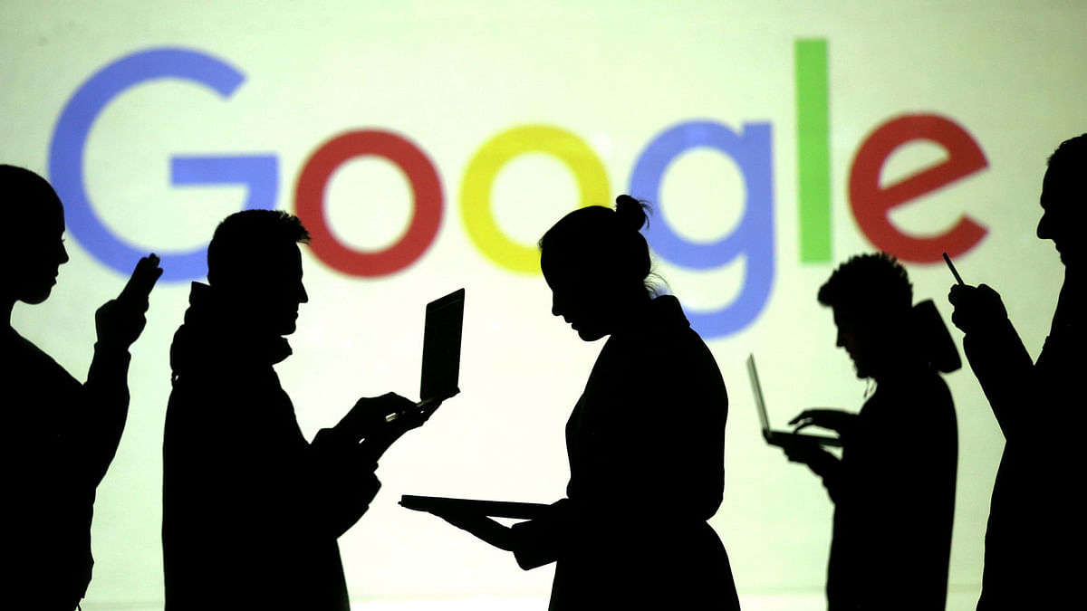 Silhouettes of laptop and mobile device users are seen next to a screen projection of Google logo in this picture illustration taken on 28 March 2018. Reuters File Photo
