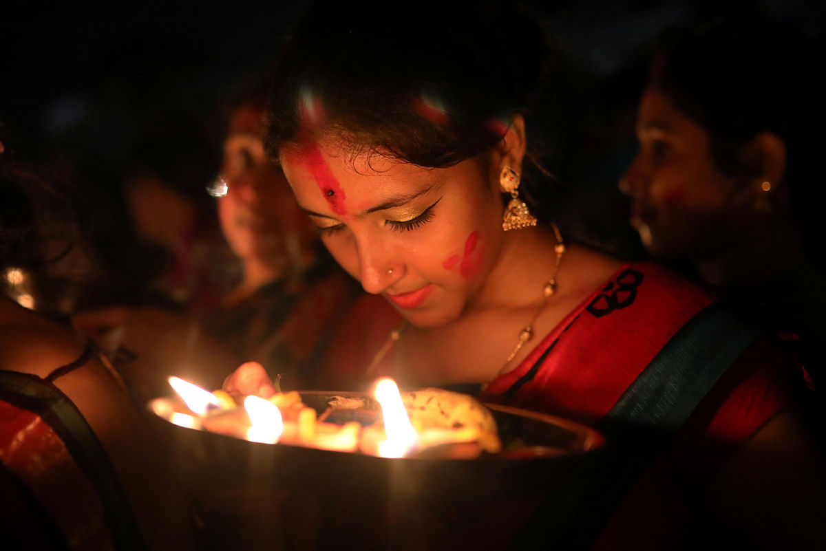 Hindu devotee women gather to release oil lamps to the Buriganga river as they observe Bipottarini Puja in Dhaka on 17 July 2018. Photo: Reuters