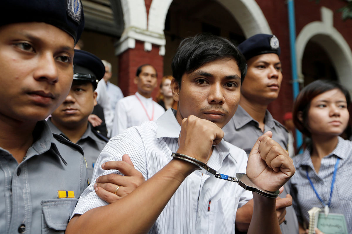 Detained Reuters journalist Wa Lone is escorted by police while leaving Insein court in Yangon. Photo: Reuters