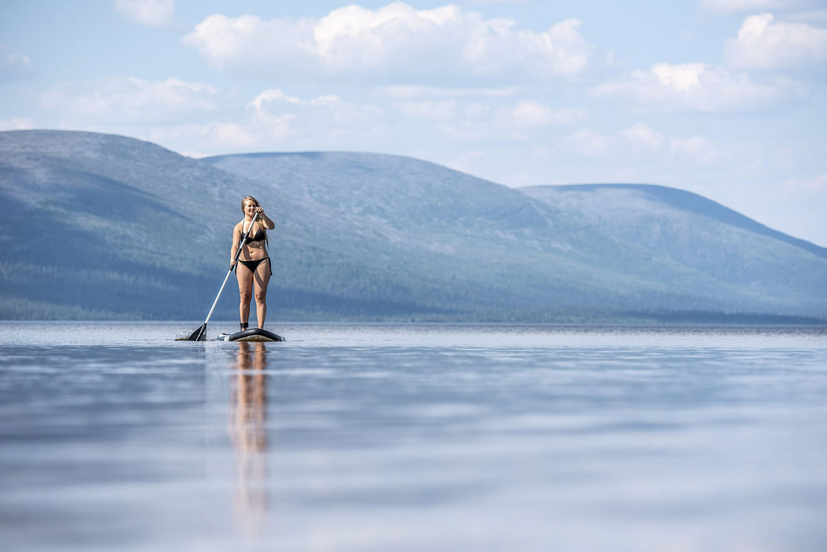 A woman enjoys the warm weather while paddling on the Pallasjarvi lake in Kittila, Lapland, Finland on 18 July 2018. Photo: Reuters