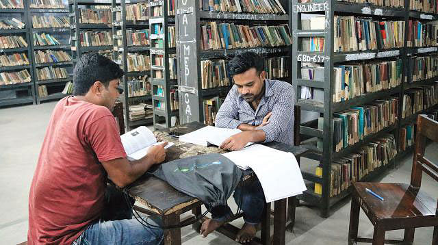 Two students are reading at a public library in Jashore