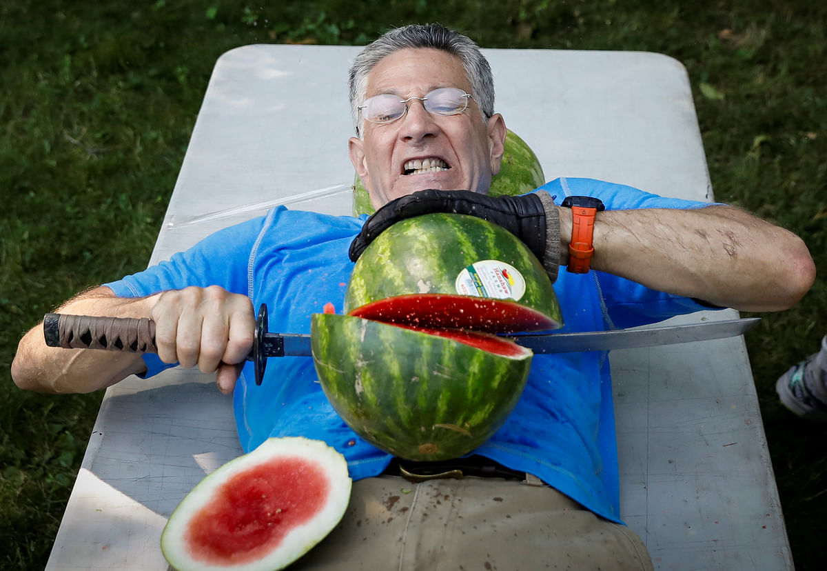 Ashrita Furman, who holds more Guinness World Records than anyone, attempts to set a new record for slicing the most watermelons in half on his own stomach in one minute in New York City, US on 17 July 2018. Photo: Reuters