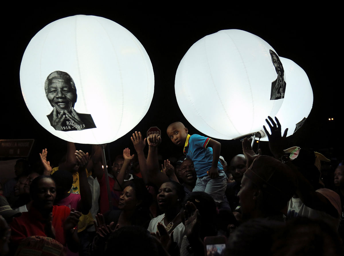 A boy looks on in front of balloons bearing a picture of former South African President Nelson Mandela on Vilakazi Street in Soweto, South Africa, 7 December 2013. Photo: Reuters