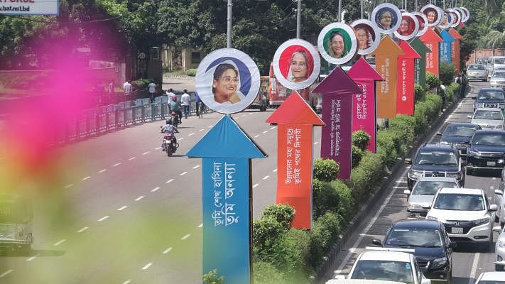 Pictures of prime minister and president of ruling Bangladesh Awami League (AL) Sheikh Hasina are seen on boards, set up on road divider in Old Airport area of Dhaka. AL is set to hold a mass reception for prime minister Sheikh Hasina on 21 July. The photograph was captured by Abdus Salam on 18 July.