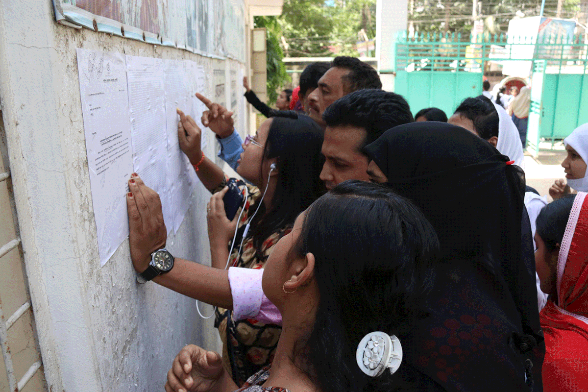 Students and parents gather to look for respective names on the result sheet pasted on the wall of Government Sarada Sundari Girls College, Faridpur. Photo: Alimuzzaman