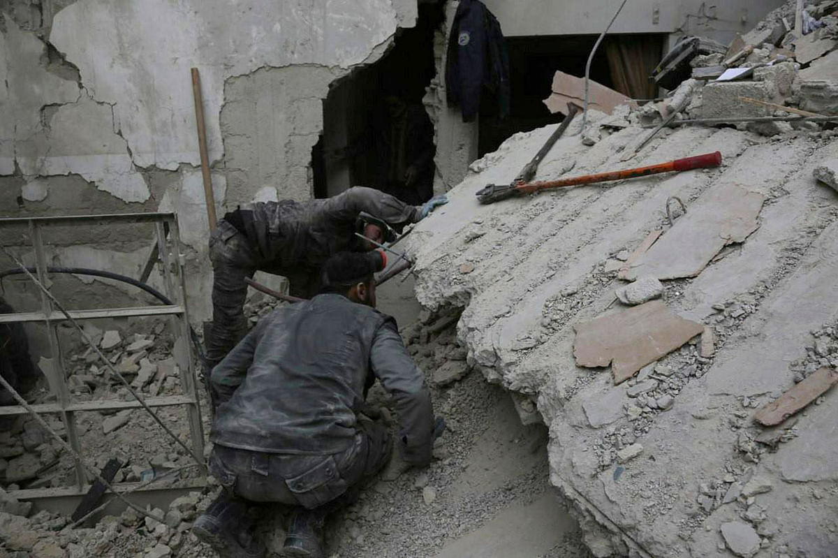 In this photo released on 21 February, 2018 which provided by the Syrian Civil Defence group known as the White Helmets, shows a member of the Syrian Civil Defence group, searches for victims under the rubble of a destroyed house that attacked by Syrian government forces airstrike, in Ghouta, a suburb of Damascus, Syria. Photo: AP